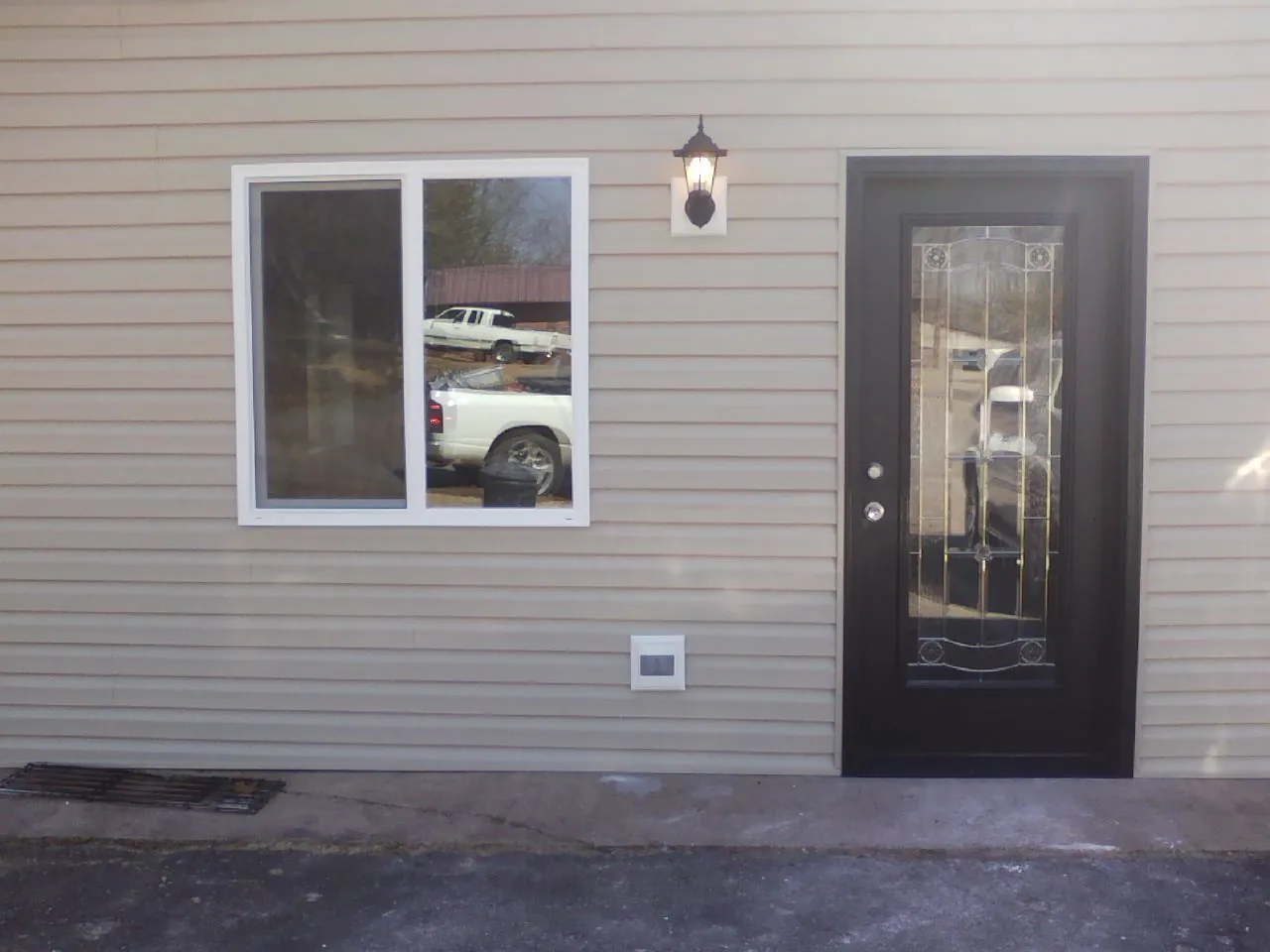 New siding, window and entry door on the side of an addition in Roggen