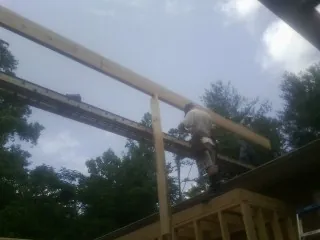 Carpenter setting a ridge beam over a new addition frame — Ice Dam Removal by Roofing Brothers in Roggen