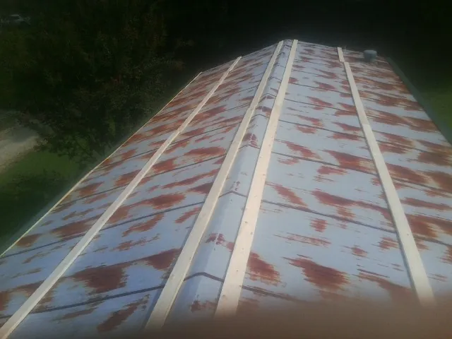 Rusted metal roof panels with new wood purlins before replacement — Storm Damage Roof Repair in Roggen by Roofing Brothers